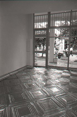 ONCE UPON A TIME... ICE BOX<br />
1994 Ongoing<br />
Posterior View<br />
Floor: American Prest-Plate Ceiling Tin Installed On Top of Gallery Floor Left for Viewers to Destroy through Abrasion with Actual Gallery Floor, Viewer Imprints,<br />
Tracks, and Traffic<br />
Variable Dimensions<br />