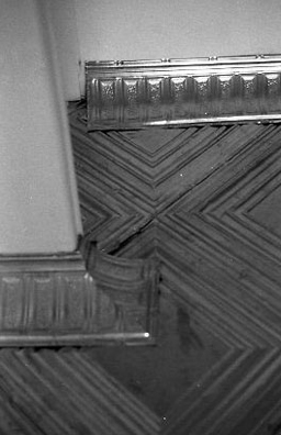 ONCE UPON A TIME... ICE BOX<br />
1994 Ongoing<br />
Detail: (Architectural Corners with Cornice)<br />
Floor: American Prest-Plate Ceiling Tin Installed On Top of Gallery Floor Left for Viewers to Destroy through Abrasion with Actual Gallery Floor, Viewer Imprints,<br /> Tracks, and Traffic<br />
Variable Dimensions<br />