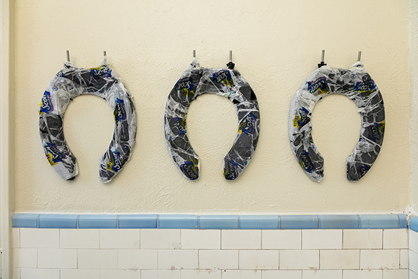 HORSESHOES, HAND GRENADES, AND DANCING<br />
2020 Ongoing<br />
Series of 3 Toilet Seats, Wrapped in Scott Toilet Paper Packaging, Mounted on Wall of Men’s Bathroom<br />
Variable Dimensions