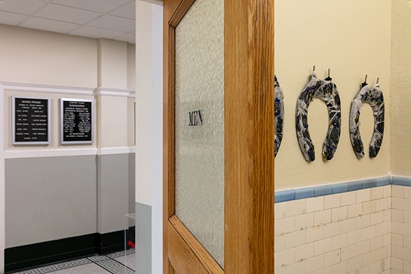 HORSESHOES, HAND GRENADES, AND DANCING<br />
2020 Ongoing<br />
Series of 3 Toilet Seats, Wrapped in Scott Toilet Paper Packaging, Mounted on Wall of Men’s Bathroom<br />
Variable Dimensions