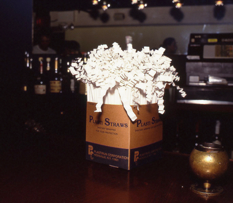SUCK<br />
1991 Ongoing<br />
Happening: Plastic Straws with Fancy Handmade Paper Tops Served in All Drinks at Various Art Fairs and Art Openings, Displayed in Bouquets in Bar Area, and as Relics<br />
Series of 10 “Straw Bouquets”, 500 Individual Straws/Bouquet<br />
Photograph of Happening NY: Sitting Pretty<br />
Edition: 2, 1 AP<br />