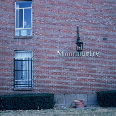 DISPLACED DENVER: THE MONMARTRE<br/>
2000 Ongoing <br/>
Cibachrome Print <br/>
Series of Denver Apartment Buildings Named After Famous Politicians, Artists, Landmarks, Neighborhoods, Beaches, Styles, Museums, Islands, Cocktails, Clothing, Pirates, Warriors, Automobiles, Restaurants, Race Tracks, Festivals, Writers, Cities, Explorers, Teams, Palaces, Stores, Poets, Song Writers, Hotels, Magazines, Fictional Places, Architectural Elements, Holidays, Etc <br/ >