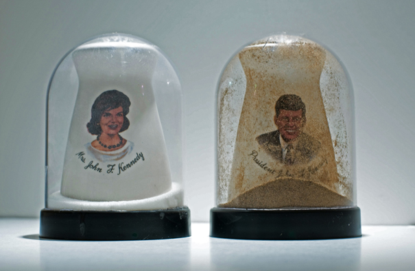 SHAKE: AN ACCUMULATED GIFT COLLECTION OF SALT AND PEPPER SHAKERS <br/>
1991 Ongoing <br/>
Detail: Gift of Melanie Flood (John and Jackie Kennedy Commemorative Shakers)<br/>
Snow Globes Altered to Become Functioning Salt and Pepper Shakers, Each Filled with Salt and Pepper, and when Used, the Diminishing Salt and Pepper Reveals the Actual Accumulated Gift Collection of Shakers<br/>
3 1/2”H x 2 1/2” in Diameter<br/>