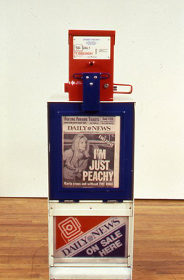 THE NEWS <br/>
1991 Ongoing <br/>
Detail: New York Daily News; “I'm Just Peachy”<br/>
Fully Operational New York Daily News Dispenser, Available for Viewers to Use for the Duration of the Exhibition, Papers Updated on Daily/Weekly Basis by Appropriate News Agencies <br/>
18” x 49” x 20” Each<br/>