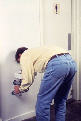 WELL <br/>
1992 Ongoing <br/>
Functioning Child's Height Drinking Fountain Installed in New Museum, Near Men's Bathroom, Available for Viewers to Drink Water Throughout the Duration of the Exhibition Being Used by Tom Powell<br/>
30” x 11” x 8” <br/>