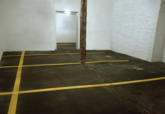 “ASPHALT JUNGLE”: PAY HERE; KOLN<br />
1991 Ongoing<br />
Floor: Asphalt Installed on Top of Gallery Floor to Create Sections of 12 Spaces of an Abstract 100 Space Parking Lot‚ Parking Lines‚ and Numbers Painted on Asphalt to Delineate Parking Spaces<br />
Detail: Spaces 86, 87, 88, 89, 90, 92, 93, 94, 95<br />
Regulation Standard Parking Spaces<br />
Variable Dimensions<br />