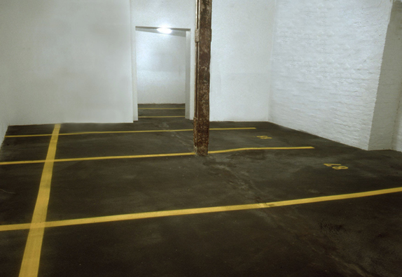 “ASPHALT JUNGLE”: PAY HERE; KOLN<br />
1991 Ongoing<br />
Floor: Asphalt Installed on Top of Gallery Floor to Create Sections of 12 Spaces of an Abstract 100 Space Parking Lot‚ Parking Lines‚ and Numbers Painted on Asphalt to Delineate Parking Spaces<br />
Detail: Spaces 86, 87, 88, 89, 90, 92, 93, 94, 95<br />
Regulation Standard Parking Spaces<br />
Variable Dimensions<br />