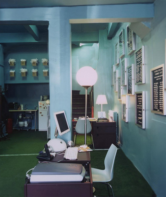 IDEAL OFFICE<br />
2002 Ongoing<br />
Walls/ Ceiling: Painted Peggy Guggenheim Blue, a Benjamin Moore Paint Color that the Artist Renamed<br />
Art Works: Suck, “What's Love Got to Do with It”<br />
Floor: The Touch of Greatness: Babe Ruth<br />
Idealized Section of Yankee Stadium Superimposed with the Ideal Office Floor<br />
2nd Base, Astroturf, Spray Painted Base Line<br />
Furniture: Magistretti Maui Chairs, Habitat Compact Desks, Artemide Lamps<br />
All Decor and Environment Selected by the Artist to Create a Unique Installation, “Ideal Office”, for the Production Firm Outcasts Incorporated<br />
Variable Dimensions<br />