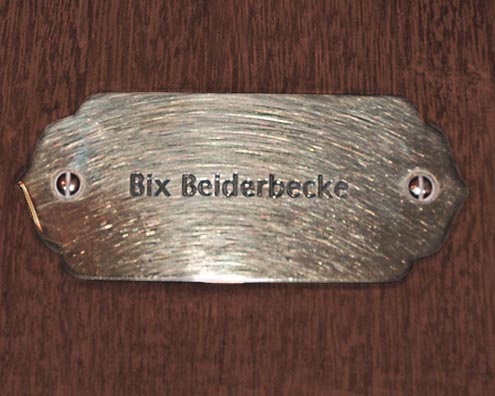 “MAMAS DON'T LET YOUR BABIES GROW UP TO BE COWBOYS”<br/>
Bix Beiderbecke<br/>
2009 ongoing <br/>
C-Print of a Name Plate Reserving a Hotel Room in Perpetuity for the Coronet/Piano Jazz Legend, Bix Beiderbecke<br/>
Mounted on Wood with Non-Glare Plexiglas Surface<br/>
7 3/4” x 9 3/4” x 3/4” <br/>