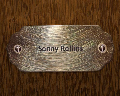 “MAMAS DON'T LET YOUR BABIES GROW UP TO BE COWBOYS”<br/>
Sonny Rollins<br/>
2009 ongoing <br/>
C-Print of a Name Plate Reserving a Hotel Room in Perpetuity for the Tenor/Soprano Jazz Legend, Sonny Rollins<br/>
Mounted on Wood with Non-Glare Plexiglas Surface<br/>
7 3/4” x 9 3/4” x 3/4” <br/>