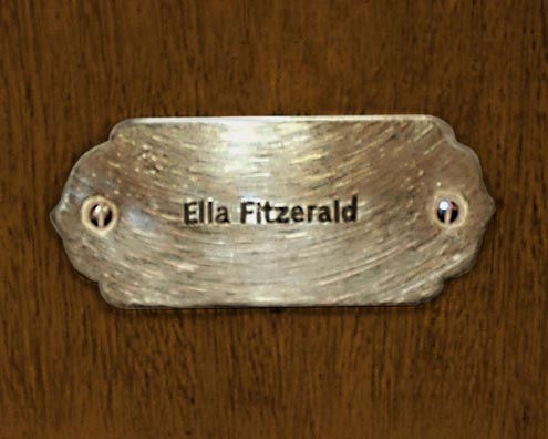 “MAMAS DON'T LET YOUR BABIES GROW UP TO BE COWBOYS”<br/>
Ella Fitzerald [Sic]<br/>
2009 ongoing <br/>
C-Print of a Name Plate Reserving a Hotel Room in Perpetuity for the Songtress Jazz Legend, Ella Fitzgerald<br/>
Mounted on Wood with Non-Glare Plexiglas Surface<br/>
7 3/4” x 9 3/4” x 3/4” <br/>