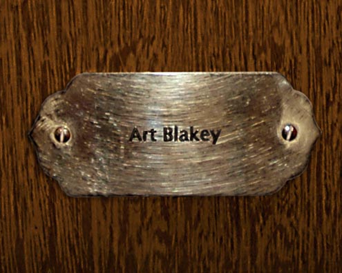 “MAMAS DON'T LET YOUR BABIES GROW UP TO BE COWBOYS”<br/>
Art Blakey<br/>
2009 ongoing <br/>
C-Print of a Name Plate Reserving a Hotel Room in Perpetuity for the Drums Jazz Legend, Art Blakey<br/>
Mounted on Wood with Non-Glare Plexiglas Surface<br/>
7 3/4” x 9 3/4” x 3/4” <br/>