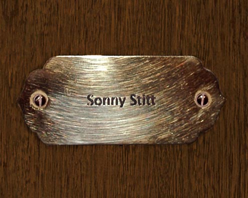 “MAMAS DON'T LET YOUR BABIES GROW UP TO BE COWBOYS”<br/>
Sonny Stitt<br/>
2009 ongoing <br/>
C-Print of a Name Plate Reserving a Hotel Room in Perpetuity for the Alto/Tenor Jazz Legend, Sonny Stitt<br/>
Mounted on Wood with Non-Glare Plexiglas Surface<br/>
7 3/4” x 9 3/4” x 3/4” <br/>