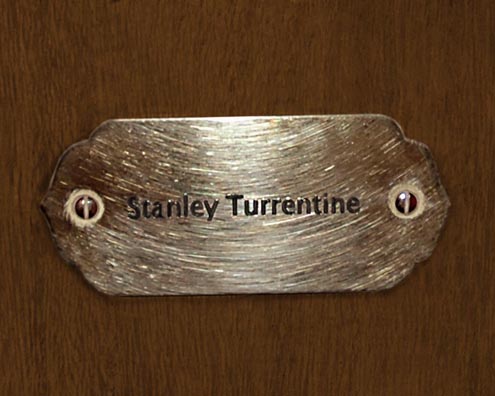 “MAMAS DON'T LET YOUR BABIES GROW UP TO BE COWBOYS”<br/>
Stanley Turrentine<br/>
2009 ongoing <br/>
C-Print of a Name Plate Reserving a Hotel Room in Perpetuity for the Tenor Sax Jazz Legend, Stanley Turrentine<br/>
Mounted on Wood with Non-Glare Plexiglas Surface<br/>
7 3/4” x 9 3/4” x 3/4” <br/>
