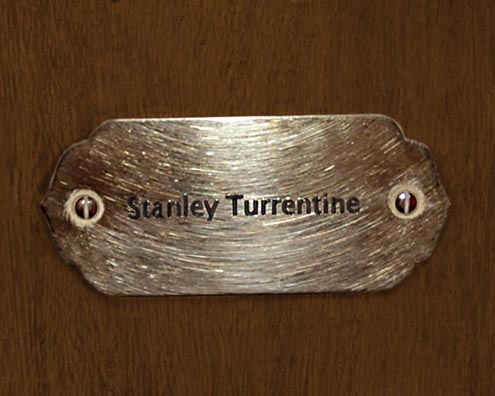 “MAMAS DON'T LET YOUR BABIES GROW UP TO BE COWBOYS”<br/>
Stanley Turrentine<br/>
2009 ongoing <br/>
C-Print of a Name Plate Reserving a Hotel Room in Perpetuity for the Tenor Sax Jazz Legend, Stanley Turrentine<br/>
Mounted on Wood with Non-Glare Plexiglas Surface<br/>
7 3/4” x 9 3/4” x 3/4” <br/>