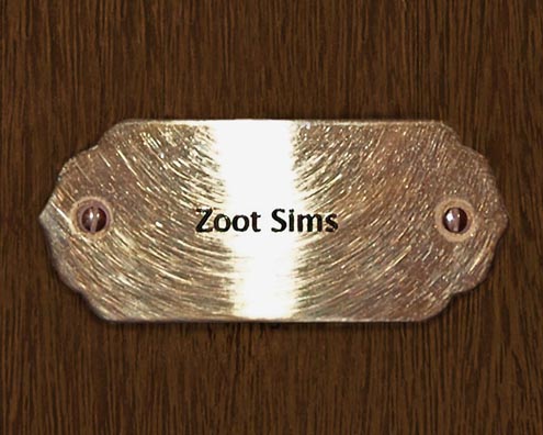 “MAMAS DON'T LET YOUR BABIES GROW UP TO BE COWBOYS”<br/>
Zoot Sims<br/>
2009 ongoing <br/>
C-Print of a Name Plate Reserving a Hotel Room in Perpetuity for the Tenor/Soprano Sax Jazz Legend, Zoot Sims<br/>
Mounted on Wood with Non-Glare Plexiglas Surface<br/>
7 3/4” x 9 3/4” x 3/4” <br/>