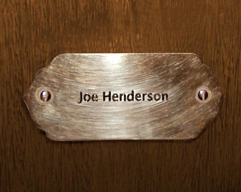 “MAMAS DON'T LET YOUR BABIES GROW UP TO BE COWBOYS”<br/>
Joe Henderson<br/>
2009 ongoing <br/>
C-Print of a Name Plate Reserving a Hotel Room in Perpetuity for the Tenor Sax Jazz Legend, Joe Henderson<br/>
Mounted on Wood with Non-Glare Plexiglas Surface<br/>
7 3/4” x 9 3/4” x 3/4” <br/>
