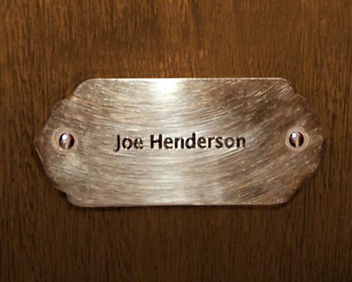 “MAMAS DON'T LET YOUR BABIES GROW UP TO BE COWBOYS”<br/>
Joe Henderson<br/>
2009 ongoing <br/>
C-Print of a Name Plate Reserving a Hotel Room in Perpetuity for the Tenor Sax Jazz Legend, Joe Henderson<br/>
Mounted on Wood with Non-Glare Plexiglas Surface<br/>
7 3/4” x 9 3/4” x 3/4” <br/>