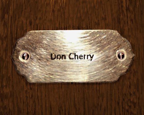 “MAMAS DON'T LET YOUR BABIES GROW UP TO BE COWBOYS”<br/>
Don Cherry<br/>
2009 ongoing <br/>
C-Print of a Name Plate Reserving a Hotel Room in Perpetuity for the Coronet/Piano Jazz Legend, Don Cherry<br/>
Mounted on Wood with Non-Glare Plexiglas Surface<br/>
7 3/4” x 9 3/4” x 3/4” <br/>