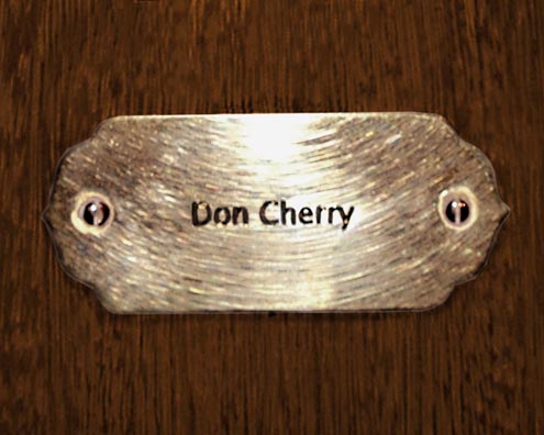 “MAMAS DON'T LET YOUR BABIES GROW UP TO BE COWBOYS”<br/>
Don Cherry<br/>
2009 ongoing <br/>
C-Print of a Name Plate Reserving a Hotel Room in Perpetuity for the Coronet/Piano Jazz Legend, Don Cherry<br/>
Mounted on Wood with Non-Glare Plexiglas Surface<br/>
7 3/4” x 9 3/4” x 3/4” <br/>