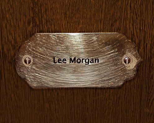 “MAMAS DON'T LET YOUR BABIES GROW UP TO BE COWBOYS”<br/>
Lee Morgan<br/>
2009 ongoing <br/>
C-Print of a Name Plate Reserving a Hotel Room in Perpetuity for the Trumpet Jazz Legend, Lee Morgan<br/>
Mounted on Wood with Non-Glare Plexiglas Surface<br/>
7 3/4” x 9 3/4” x 3/4” <br/>