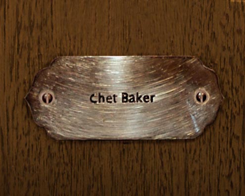 “MAMAS DON'T LET YOUR BABIES GROW UP TO BE COWBOYS”<br/>
Chet Baker<br/>
2009 ongoing <br/>
C-Print of a Name Plate Reserving a Hotel Room in Perpetuity for the Trumpet Jazz Legend, Chet Baker<br/>
Mounted on Wood with Non-Glare Plexiglas Surface<br/>
7 3/4” x 9 3/4” x 3/4” <br/>