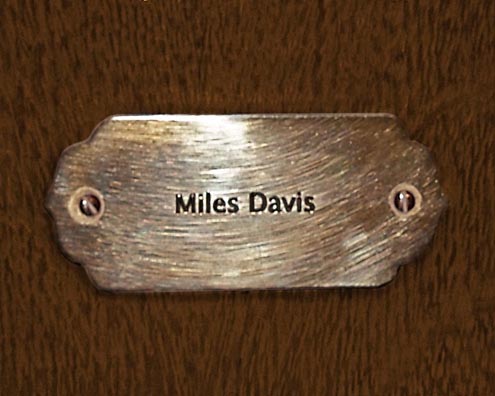 “MAMAS DON'T LET YOUR BABIES GROW UP TO BE COWBOYS”<br/>
Miles Davis<br/>
2009 ongoing <br/>
C-Print of a Name Plate Reserving a Hotel Room in Perpetuity for the Multifarious Jazz Legend, Miles Davis<br/>
Mounted on Wood with Non-Glare Plexiglas Surface<br/>
7 3/4” x 9 3/4” x 3/4” <br/>