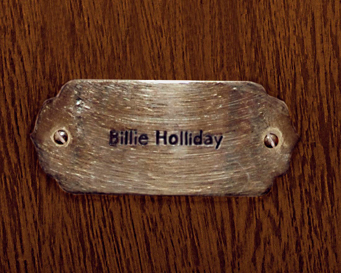 “MAMAS DON'T LET YOUR BABIES GROW UP TO BE COWBOYS”<br/>
Billie Holliday [Sic]<br/>
2009 ongoing <br/>
C-Print of a Name Plate Reserving a Hotel Room in Perpetuity for the Songstress Jazz Legend, Billie Holiday<br/>
Mounted on Wood with Non-Glare Plexiglas Surface<br/>
7 3/4” x 9 3/4” x 3/4” <br/>