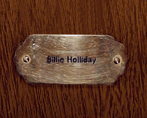 “MAMAS DON'T LET YOUR BABIES GROW UP TO BE COWBOYS”<br/>
Billie Holliday [Sic]<br/>
2009 ongoing <br/>
C-Print of a Name Plate Reserving a Hotel Room in Perpetuity for the Songstress Jazz Legend, Billie Holiday<br/>
Mounted on Wood with Non-Glare Plexiglas Surface<br/>
7 3/4” x 9 3/4” x 3/4” <br/>