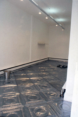 ONCE UPON A TIME... INDEPENDENT ART SPACE<br />
1994 Ongoing<br />
Anterior View<br />
Floor: American Prest-Plate Ceiling Tin Installed on Top of Gallery Floor Left for Viewers to Destroy through Abrasion with Actual Gallery Floor, Viewer Imprints,<br /> Tracks, and Traffic<br />
Variable Dimensions<br />