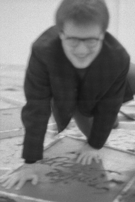 NORMA TALMADGE'S CHINESE THEATER: THE EUROPEAN LEG; KOLN<br />
1992 Ongoing<br />
Happening: Viewer's Immortalizing Themselves by Making Imprints in Fresh Cement in Homage to the Forgotten Silent Diva, Norma Talmadge, the Accidental Auteur of the Canonical Practice<br />
Photograph of Happening Displayed in Collector's Edition Photograph Book: “Smilin' Through” (1922)<br />
4” x 6”<br />