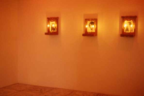 NORMA TALMADGE'S CHINESE THEATER: LA<br />
1992 Ongoing<br />
Walls: 3 Chinese Altars with Publicity Photographs of Norma Talmadge, Candles<br />
Floor: Viewers' Cement Imprints Photograph of Norma Talmadge, Table, Table Cloth<br />
Ceiling: Red and Yellow Lights<br/ >
Variable Dimensions<br />