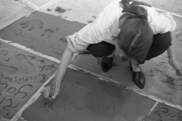 NORMA TALMADGE'S CHINESE THEATER: LA<br />
1992 Ongoing<br />
Happening: Viewers Immortalizing Themselves by Making Imprints in Fresh Cement in Homage to Forgotten Silent Diva, Norma Talmadge, the Accidental Auteur of the Canonical Practice<br />
Photograph of Happening Displayed in Collector's Edition Photograph Book: “Fortunes of a Composer” (1912)<br />
4” x 6”<br />