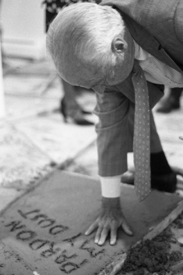 NORMA TALMADGE'S CHINESE THEATER: THE OFF BROADWAY REVIEW; NY<br />
1992 Ongoing<br />
Happening: Viewers Immortalizing Themselves by Making Imprints in Fresh Cement in Homage to the Forgotten Silent Diva, Norma Talmadge, the Accidental Auteur of the Canonical Practice<br />
Photograph of Happening Displayed on Wall in Collector's Edition Photograph Book: George Boynton, “Camille” (1926)<br />
4” x 6”<br />