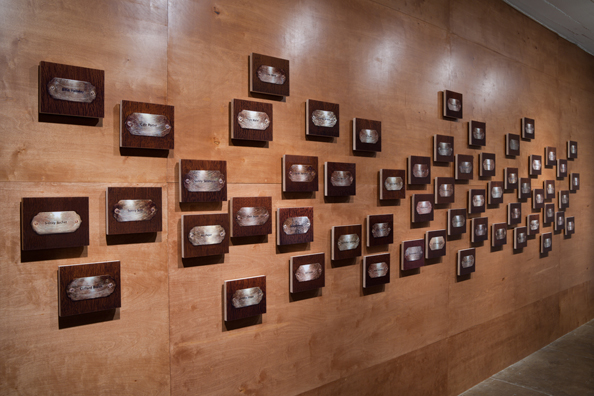 “MAMAS DON'T LET YOUR BABIES GROW UP TO BE COWBOYS”<br/>
2009 ongoing <br/>
Lateral View<br/>
Wall: 56 C-Prints of Name Plates Reserving Hotel Rooms in Perpetuity for 56 Jazz Legends Mounted on Wood with Non-Glare Plexiglas Surface and Installed on a Wall of Wood Paneling<br/>
C-Prints: 7 3/4” x 9 3/4” x 3/4” Each<br/>