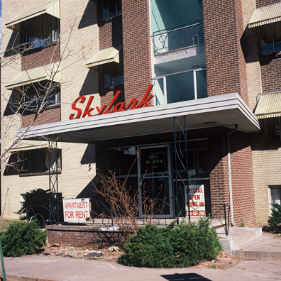 DISPLACED DENVER: THE SKYLARK<br/>
2000 Ongoing <br/>
Cibachrome Print <br/>
Series of Denver Apartment Buildings Named After Famous Politicians, Artists, Landmarks, Neighborhoods, Beaches, Styles, Museums, Islands, Cocktails, Clothing, Pirates, Warriors, Automobiles, Restaurants, Race Tracks, Festivals, Writers, Cities, Explorers, Teams, Palaces, Stores, Poets, Song Writers, Hotels, Magazines, Fictional Places, Architectural Elements, Holidays, Etc <br/ >